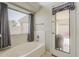 Bright bathroom with a soaking tub, window, and access to the backyard patio at 43727 W Wade Dr, Maricopa, AZ 85138