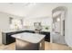 A lovely kitchen showcases black lower cabinets, a white island, and white upper cabinets at 43727 W Wade Dr, Maricopa, AZ 85138