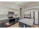 Kitchen with updated stainless steel appliances, and a beautiful large kitchen island for prep space at 43727 W Wade Dr, Maricopa, AZ 85138