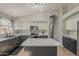 Modern kitchen featuring white cabinets, dark countertops, and an island with elegant marble countertop at 43727 W Wade Dr, Maricopa, AZ 85138