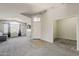 Spacious living room with carpet flooring, neutral paint, and a bank of windows for natural light at 43727 W Wade Dr, Maricopa, AZ 85138