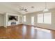 Open-concept living area with hardwood floors, built in shelves, and a ceiling fan at 43727 W Wade Dr, Maricopa, AZ 85138