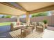 This covered patio has outdoor seating, a rug, and a view of the backyard at 43727 W Wade Dr, Maricopa, AZ 85138
