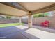 Inviting covered patio with decorative columns, concrete flooring, and low-maintenance landscaping, ideal for outdoor relaxing at 43727 W Wade Dr, Maricopa, AZ 85138