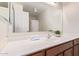 Bright bathroom features a white countertop, large mirror, and a single sink with brown wood cabinets at 45539 W Long Way, Maricopa, AZ 85139