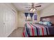 Inviting bedroom with ceiling fan, plush carpeting, closet, and window with blue curtains at 45539 W Long Way, Maricopa, AZ 85139