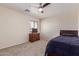 Neutral bedroom with carpet, a dark wood dresser under the window, and a bed with a navy blue comforter at 45539 W Long Way, Maricopa, AZ 85139