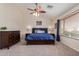 Cozy bedroom with a wood framed bed, carpeted floors, ceiling fan and natural light from window at 45539 W Long Way, Maricopa, AZ 85139