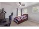 Clean bedroom with single bed, ceiling fan, plush carpeting, and natural light from the window at 45539 W Long Way, Maricopa, AZ 85139