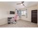 Cozy bedroom featuring a pink gaming chair, a desk, a bookshelf, and a window at 45539 W Long Way, Maricopa, AZ 85139
