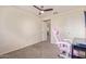 Carpeted bedroom features a pink gaming chair, a desk, and a window for great light at 45539 W Long Way, Maricopa, AZ 85139