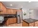 Kitchen with wooden cabinets, stainless steel appliances, and a pantry door at 45539 W Long Way, Maricopa, AZ 85139