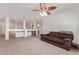 Open-concept living room with desk space, carpet, and a brown couch for optimal comfort at 45539 W Long Way, Maricopa, AZ 85139