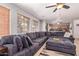 Spacious living room features a large sectional sofa, wood blinds, and open floor plan to kitchen at 45539 W Long Way, Maricopa, AZ 85139