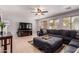 Comfortable living room featuring a large sofa, tile flooring, and a ceiling fan at 45539 W Long Way, Maricopa, AZ 85139