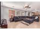 Spacious living room featuring a large sofa, tile flooring, and natural lighting at 45539 W Long Way, Maricopa, AZ 85139