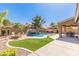 Backyard pool and patio with waterfall feature, outdoor dining, seating, and green turf at 45539 W Long Way, Maricopa, AZ 85139