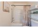Clean bathroom featuring a shower-tub, decorative shower curtain, and convenient shelving at 4642 E Sierrita Rd, San Tan Valley, AZ 85143