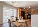 Bright dining area with wood table set for four, black appliances and view to backyard at 4642 E Sierrita Rd, San Tan Valley, AZ 85143