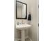 Contemporary powder room featuring a pedestal sink, framed mirror, and modern fixtures at 5109 E Helena Dr, Scottsdale, AZ 85254