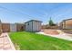 Well-kept backyard with green lawn, storage shed, and charming patio area at 5243 W Vernon Ave, Phoenix, AZ 85035