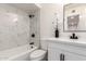 Updated bathroom featuring marble-look tile, a vanity with a modern sink, and sleek, dark hardware at 5243 W Vernon Ave, Phoenix, AZ 85035
