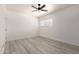 This bedroom features a ceiling fan and a window offering natural light, with wood-look flooring throughout at 5243 W Vernon Ave, Phoenix, AZ 85035