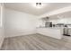 Open floor plan view of kitchen with white cabinets and stainless steel appliances and wood-look flooring at 5243 W Vernon Ave, Phoenix, AZ 85035