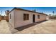 Exterior view of a detached structure showing entry door, window, and gravel landscaping at 6430 W Thomas Rd, Phoenix, AZ 85033
