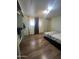 Bedroom featuring wood floors, a bed, curtains, and ample closet space at 6439 W Myrtle Ave # 49, Glendale, AZ 85301