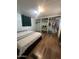 Bedroom featuring wood flooring, an open closet, and a comfortable bed at 6439 W Myrtle Ave # 49, Glendale, AZ 85301