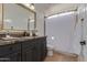 Bathroom featuring a marble countertop, vanity, and tiled shower with curtain at 7222 E Gainey Ranch Rd # 245, Scottsdale, AZ 85258
