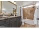 Bathroom featuring a marble countertop, vanity, and tiled shower with glass door at 7222 E Gainey Ranch Rd # 245, Scottsdale, AZ 85258