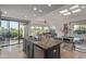 Expansive kitchen with dark cabinetry, travertine floors, stainless steel appliances, and views of the living room at 7222 E Gainey Ranch Rd # 245, Scottsdale, AZ 85258