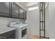 Well-lit laundry room with gray cabinets, modern washer and dryer, and an organizing ladder at 7222 E Gainey Ranch Rd # 245, Scottsdale, AZ 85258