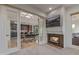 Cozy living room with a stone fireplace, tv and glass doors leading to a kitchen and dining area at 7222 E Gainey Ranch Rd # 245, Scottsdale, AZ 85258