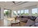 Inviting living room with golf course views, featuring travertine floors, large windows, and comfortable sectional couch at 7222 E Gainey Ranch Rd # 245, Scottsdale, AZ 85258