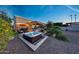 Backyard featuring a hot tub, covered kitchen, fireplace, and patio area at 7230 W Pershing Ave, Peoria, AZ 85381