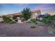 A backyard with an outdoor kitchen and gazebo with lush green plants and gravel at 7230 W Pershing Ave, Peoria, AZ 85381