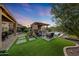 A backyard featuring an outdoor kitchen, fire pit, spa, and ample entertainment space at 7230 W Pershing Ave, Peoria, AZ 85381