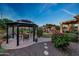 Beautiful backyard showcasing a gazebo, outdoor fireplace, covered patio, and lush landscaping at 7230 W Pershing Ave, Peoria, AZ 85381