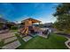 Outdoor oasis featuring a covered kitchen, fireplace, hot tub, and seating at 7230 W Pershing Ave, Peoria, AZ 85381