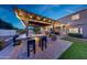 Backyard with covered kitchen, fireplace, barstool seating, and patio at 7230 W Pershing Ave, Peoria, AZ 85381