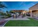 A backyard with an outdoor kitchen, fireplace, and covered patio, perfect for entertaining at 7230 W Pershing Ave, Peoria, AZ 85381