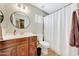 Well-lit bathroom features vanity, white countertops, a round mirror and shower with curtain at 7230 W Pershing Ave, Peoria, AZ 85381