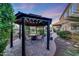 A gazebo with a fire pit and chairs, surrounded by lush landscaping at 7230 W Pershing Ave, Peoria, AZ 85381