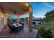 Covered patio with a dining table and backyard view, featuring an outdoor kitchen and gazebo at 7230 W Pershing Ave, Peoria, AZ 85381