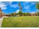 Expansive backyard featuring a lush lawn, swimming pool, and mature landscaping at 7236 W Electra Ln, Peoria, AZ 85383