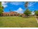 Expansive backyard showcasing a swimming pool, lush lawn, patio seating, and mature landscaping at 7236 W Electra Ln, Peoria, AZ 85383