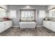 Bright bathroom features a modern tub centered between two vanities with white cabinetry and updated fixtures at 7236 W Electra Ln, Peoria, AZ 85383